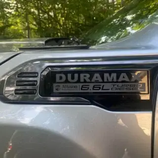 Gloss black Sierra HD Duramax fender insert overlays installed on a 2020-2027 GMC Sierra 2500HD